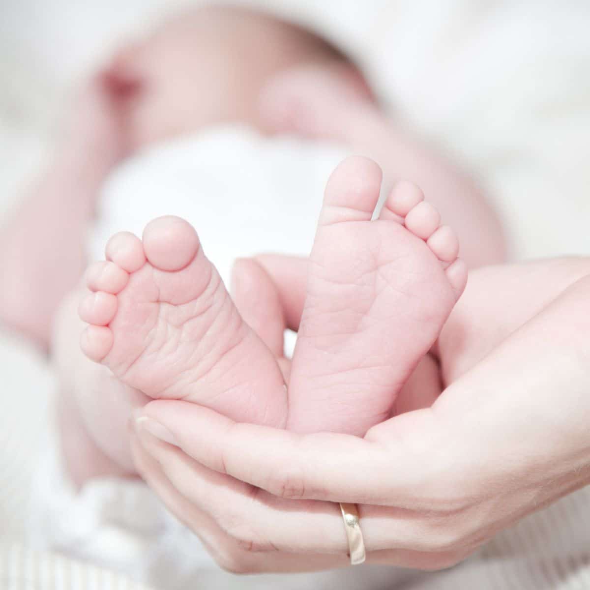 Woman holding up baby feet while baby is sleeping