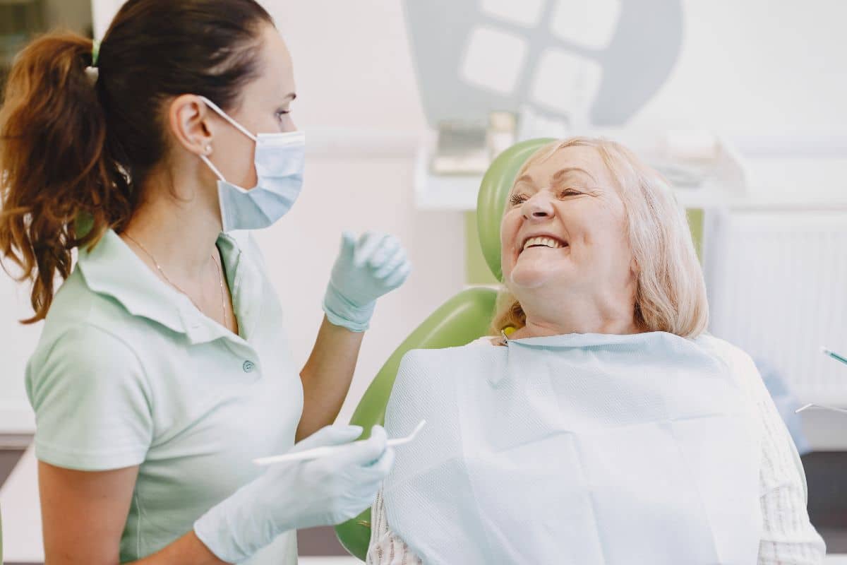 Patient in dental chair smiling at dentist