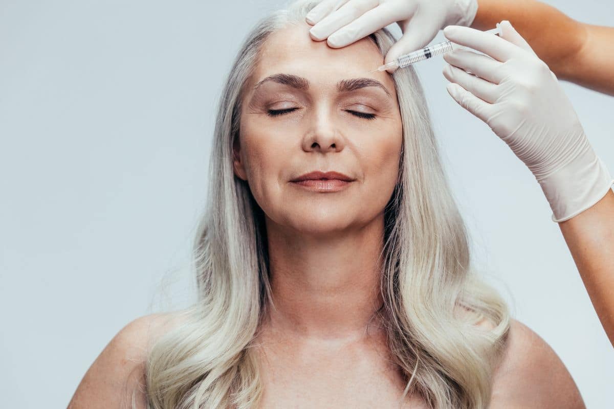 Woman getting botox injection in forehead