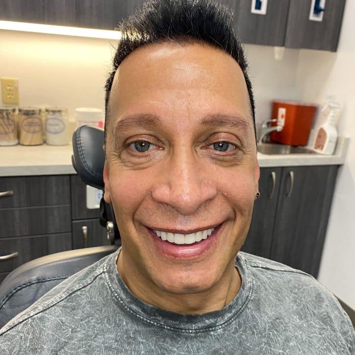 man sitting in dentist chair smiling